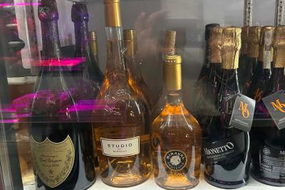 Bouteilles de vin inclinées et empilées horizontalement sur un présentoir en bois.