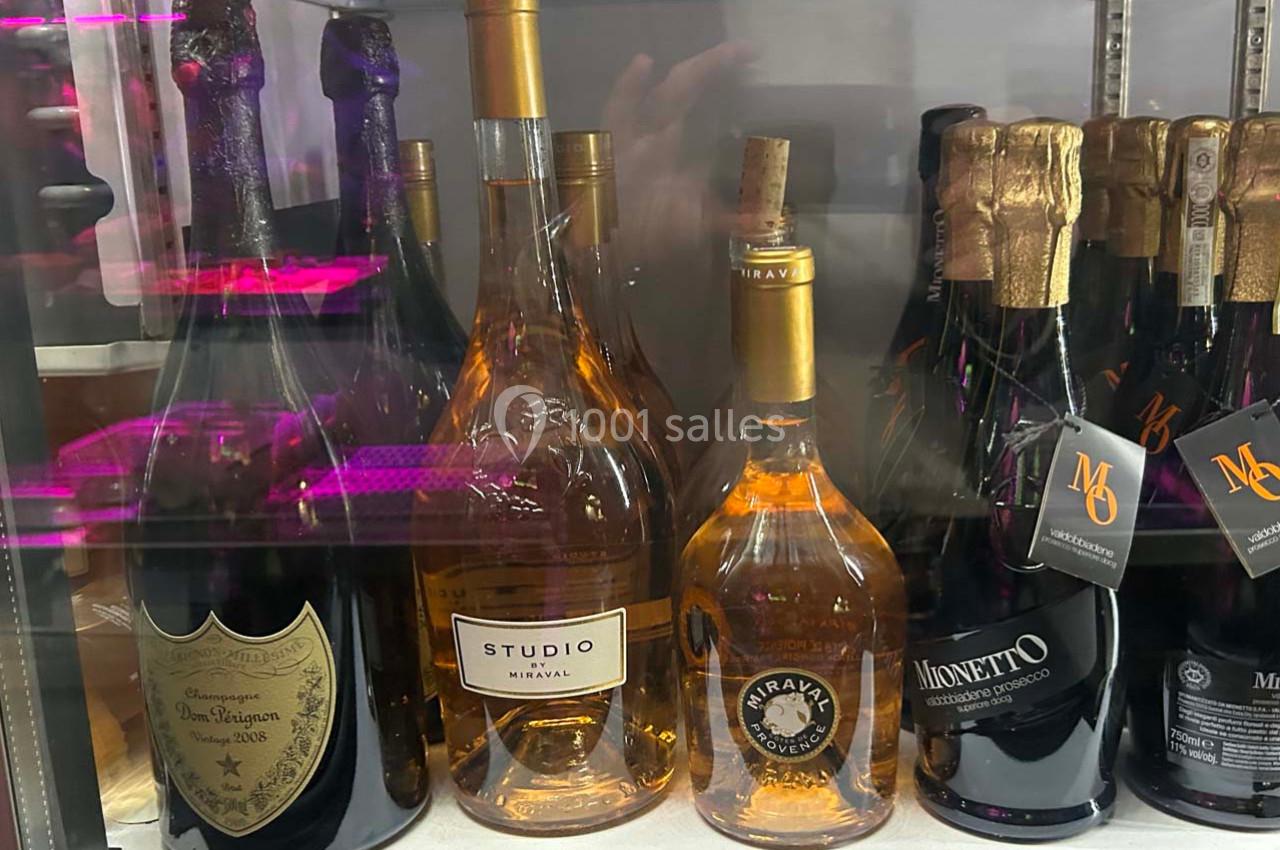 Bouteilles de vin et de champagne variées exposées dans un réfrigérateur.