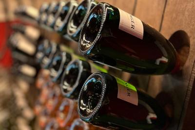 Bouteilles de vin inclinées et empilées horizontalement sur un présentoir en bois.