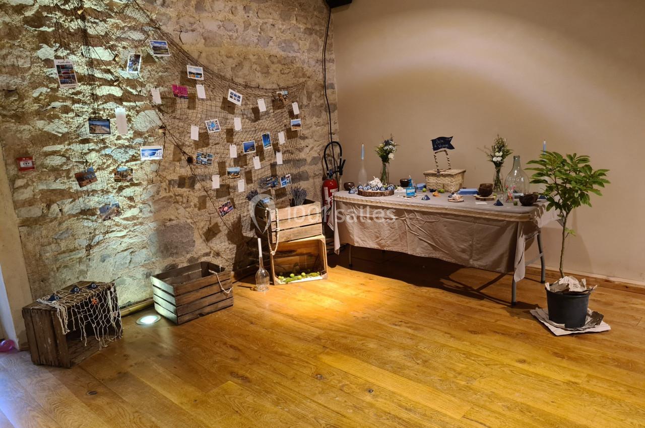 Décoration intérieure avec thème marin, comprenant des caisses en bois, un filet, des photos suspendues et une table dressée.