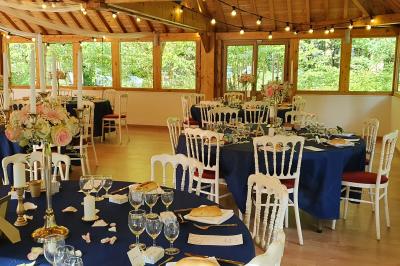 Miniature Location salle Villeneuve-le-Comte (Seine-et-Marne) - Le Domaine de La Pointe #13 Salle de réception décorée avec des guirlandes lumineuses, des tables rondes dressées et un plafond en bois apparent.