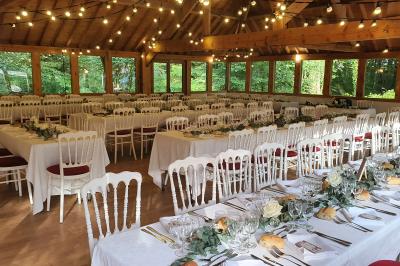 Miniature Location salle Villeneuve-le-Comte (Seine-et-Marne) - Le Domaine de La Pointe #14 Salle de réception décorée avec des guirlandes lumineuses, des tables rondes dressées et un plafond en bois apparent.