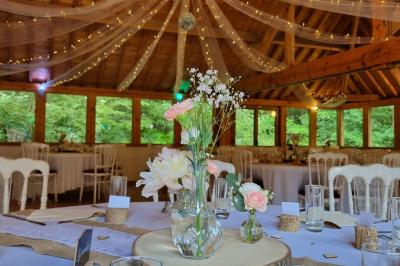 Miniature Location salle Villeneuve-le-Comte (Seine-et-Marne) - Le Domaine de La Pointe #6 Salle de réception décorée avec des guirlandes lumineuses, des tables rondes dressées et un plafond en bois apparent.