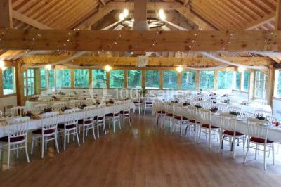 Miniature Location salle Villeneuve-le-Comte (Seine-et-Marne) - Le Domaine de La Pointe #9 Salle de réception décorée avec des guirlandes lumineuses, des tables rondes dressées et un plafond en bois apparent.