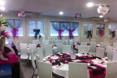 Cuisine professionnelle équipée avec plans de travail en inox, évier double, étagères murales et hotte d'extraction.