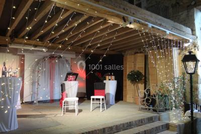 Lit simple avec couvre-lit fleuri dans une chambre lumineuse, éclairée par une lampe de chevet près d'une fenêtre.