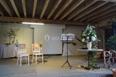 Lit simple avec couvre-lit fleuri dans une chambre lumineuse, éclairée par une lampe de chevet près d'une fenêtre.