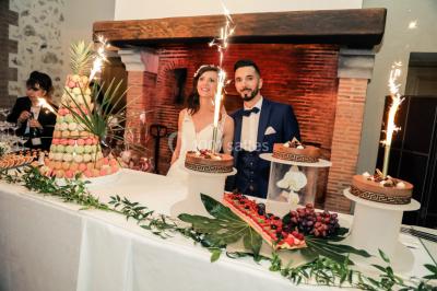Lit simple avec couvre-lit fleuri dans une chambre lumineuse, éclairée par une lampe de chevet près d'une fenêtre.