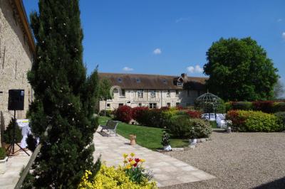 Lit simple avec couvre-lit fleuri dans une chambre lumineuse, éclairée par une lampe de chevet près d'une fenêtre.
