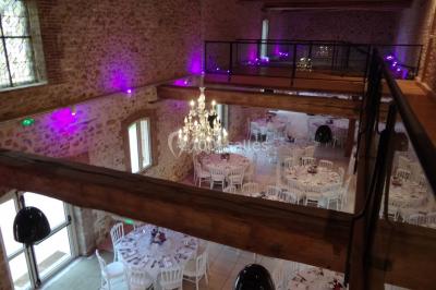 Lit simple avec couvre-lit fleuri dans une chambre lumineuse, éclairée par une lampe de chevet près d'une fenêtre.