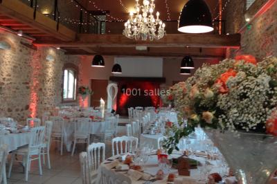 Lit simple avec couvre-lit fleuri dans une chambre lumineuse, éclairée par une lampe de chevet près d'une fenêtre.