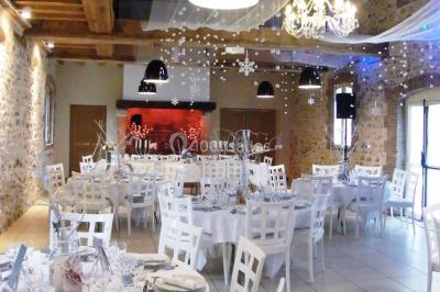 Lit simple avec couvre-lit fleuri dans une chambre lumineuse, éclairée par une lampe de chevet près d'une fenêtre.