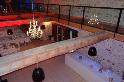 Lit simple avec couvre-lit fleuri dans une chambre lumineuse, éclairée par une lampe de chevet près d'une fenêtre.