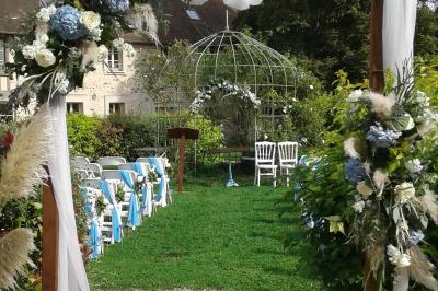Lit simple avec couvre-lit fleuri dans une chambre lumineuse, éclairée par une lampe de chevet près d'une fenêtre.