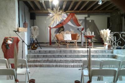 Lit simple avec couvre-lit fleuri dans une chambre lumineuse, éclairée par une lampe de chevet près d'une fenêtre.