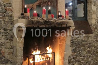 Cour extérieure éclairée en soirée, avec un grand arbre central, des tables, des palettes en bois et des invités debout.
