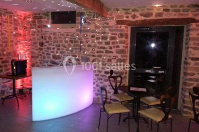 Cabane en bois perchée dans les arbres avec une passerelle en bois, entourée de végétation automnale et deux vélos au…