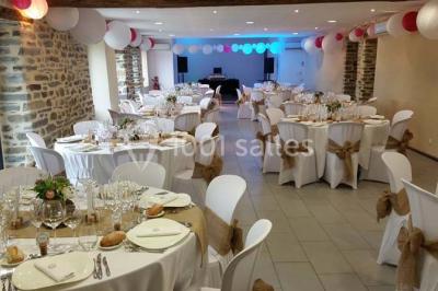 Cabane en bois perchée dans les arbres avec une passerelle en bois, entourée de végétation automnale et deux vélos au…