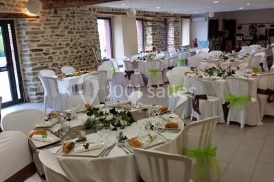 Cabane en bois perchée dans les arbres avec une passerelle en bois, entourée de végétation automnale et deux vélos au…