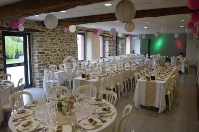 Cabane en bois perchée dans les arbres avec une passerelle en bois, entourée de végétation automnale et deux vélos au…
