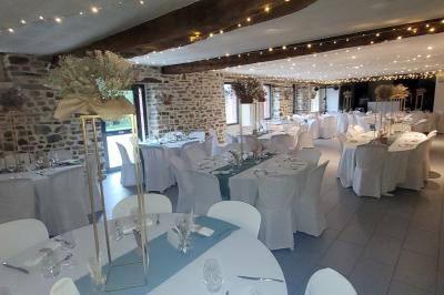 Cabane en bois perchée dans les arbres avec une passerelle en bois, entourée de végétation automnale et deux vélos au…