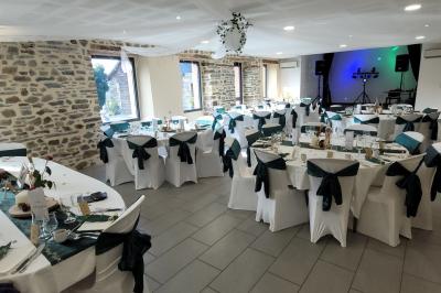 Cabane en bois perchée dans les arbres avec une passerelle en bois, entourée de végétation automnale et deux vélos au…