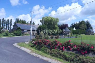 Cabane en bois perchée dans les arbres avec une passerelle en bois, entourée de végétation automnale et deux vélos au…