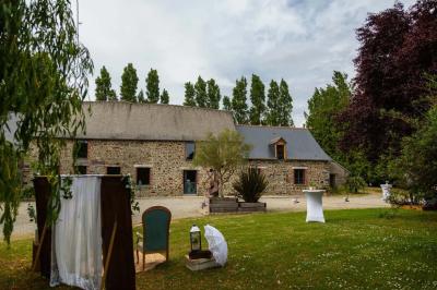 Cabane en bois perchée dans les arbres avec une passerelle en bois, entourée de végétation automnale et deux vélos au…