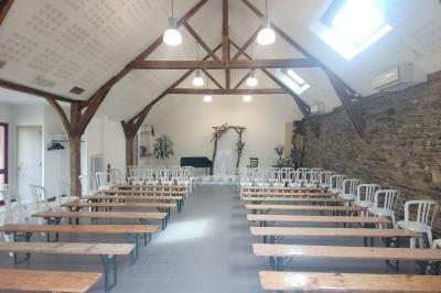 Cabane en bois perchée dans les arbres avec une passerelle en bois, entourée de végétation automnale et deux vélos au…