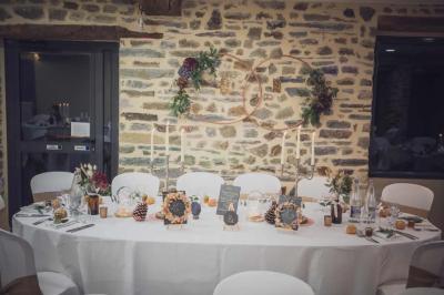 Cabane en bois perchée dans les arbres avec une passerelle en bois, entourée de végétation automnale et deux vélos au…