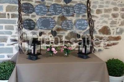 Cabane en bois perchée dans les arbres avec une passerelle en bois, entourée de végétation automnale et deux vélos au…