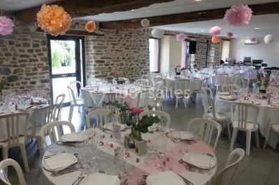 Cabane en bois perchée dans les arbres avec une passerelle en bois, entourée de végétation automnale et deux vélos au…