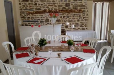 Cabane en bois perchée dans les arbres avec une passerelle en bois, entourée de végétation automnale et deux vélos au…