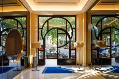 Piscine intérieure avec chaises longues rayées, éclairage doux et grande fenêtre ronde donnant sur l'extérieur.