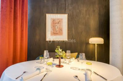 Piscine intérieure avec chaises longues rayées, éclairage doux et grande fenêtre ronde donnant sur l'extérieur.