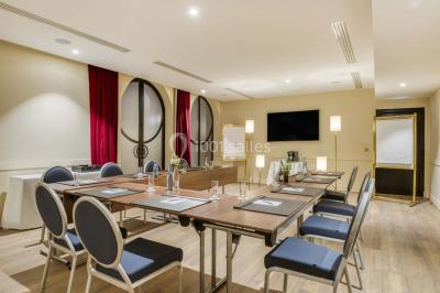 Piscine intérieure avec chaises longues rayées, éclairage doux et grande fenêtre ronde donnant sur l'extérieur.