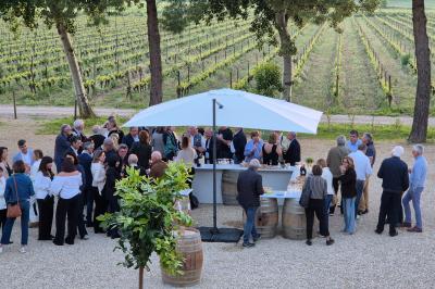 Salle avec des participants assis face à une présentation, entourée de drapeaux publicitaires et d'éléments décoratifs.