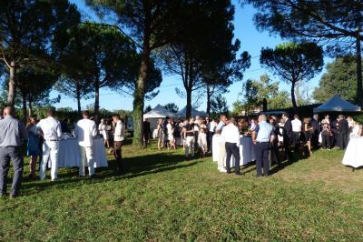 Salle avec des participants assis face à une présentation, entourée de drapeaux publicitaires et d'éléments décoratifs.