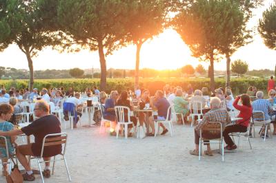 Salle avec des participants assis face à une présentation, entourée de drapeaux publicitaires et d'éléments décoratifs.