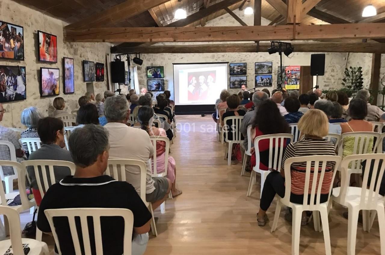 Un groupe de personnes assises dans une salle regardant une projection sur un écran.