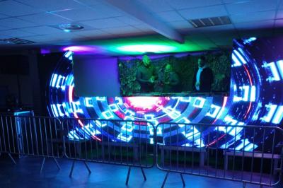 Salle vide avec un sol en carrelage gris foncé, des murs clairs et des portes rouges visibles en arrière-plan.