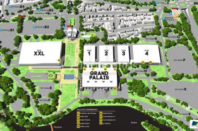 Bâtiment moderne avec façade vitrée, éclairé au crépuscule, reflété dans un plan d'eau calme.