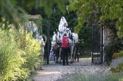Salle de réunion avec des tables blanches, des chaises en osier et un écran de projection, dans un cadre en briques…