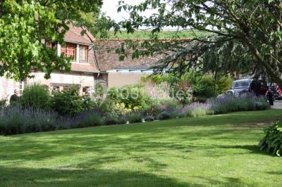 Salle de réunion avec des tables blanches, des chaises en osier et un écran de projection, dans un cadre en briques…
