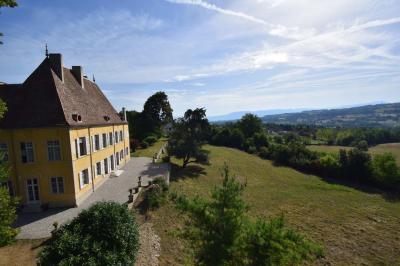 Façade d'un grand bâtiment ancien éclairé la nuit, entouré de petites lumières au sol.