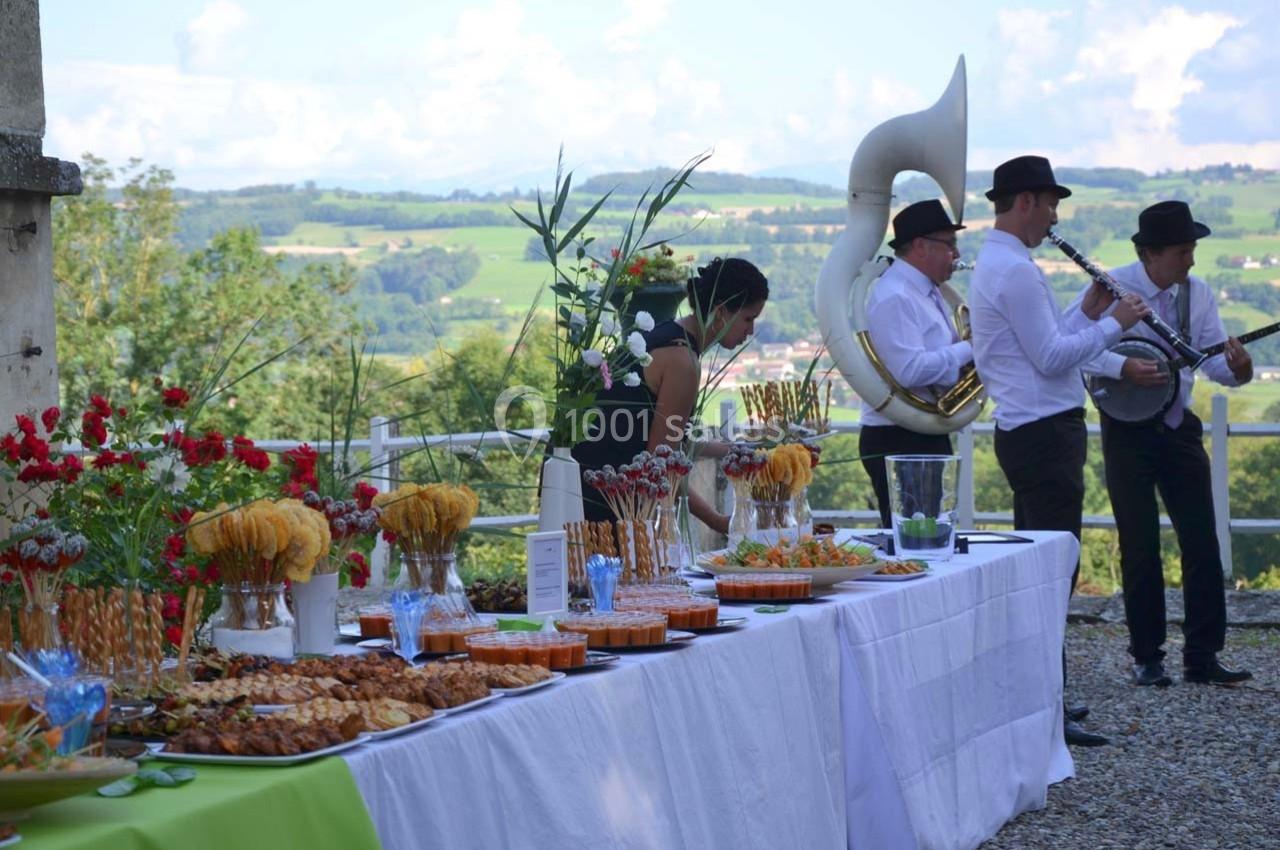 Un buffet en plein air avec des musiciens jouant en arrière-plan dans un cadre champêtre.