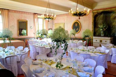 Façade d'un grand bâtiment ancien éclairé la nuit, entouré de petites lumières au sol.