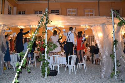 Façade d'un grand bâtiment ancien éclairé la nuit, entouré de petites lumières au sol.