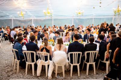 Façade d'un grand bâtiment ancien éclairé la nuit, entouré de petites lumières au sol.