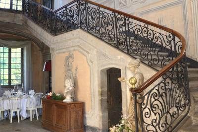 Façade d'un grand bâtiment ancien éclairé la nuit, entouré de petites lumières au sol.